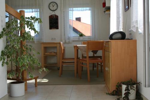 a dining room with a table and chairs and a clock at Ferienhaus Auszeit in Waldsolms