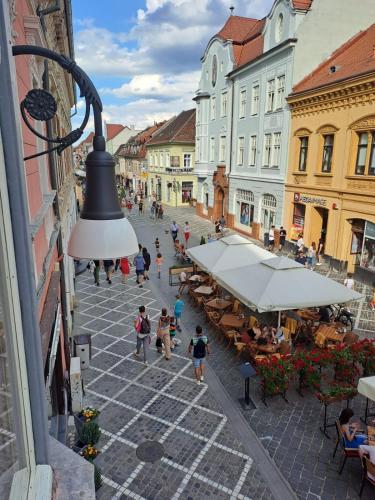 a city street with people walking and tables and buildings at Clasic Studio Central in Braşov