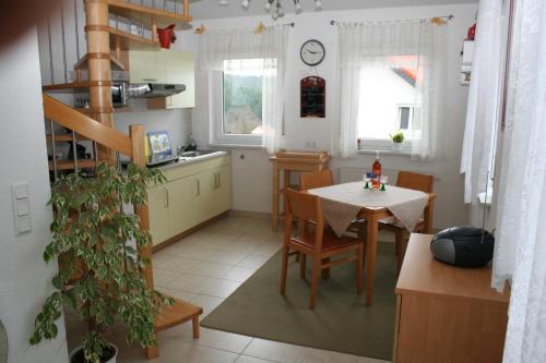 una cucina e una sala da pranzo con tavolo e sedie di Ferienhaus Auszeit a Waldsolms