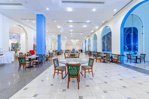 a dining room with tables and chairs and blue columns at Siva Sharm Resort & SPA in Sharm El Sheikh