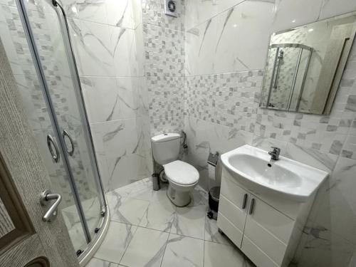 een badkamer met een toilet, een wastafel en een douche bij Милениум 2 in Sveti Vlas