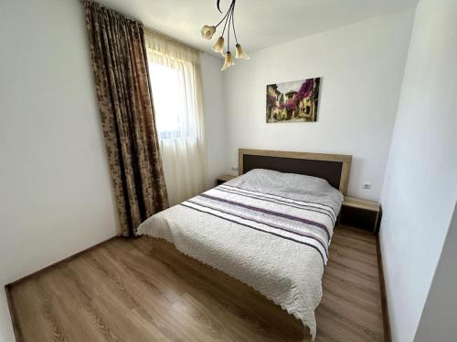 een slaapkamer met een bed in een kamer met een raam bij Милениум 2 in Sveti Vlas