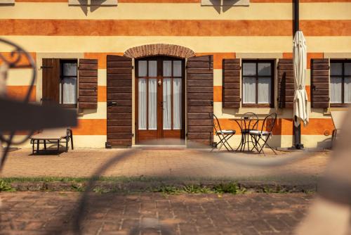 a building with a table and chairs in front of it at Musella Winery & Relais in San Martino Buon Albergo