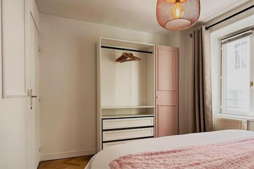- une chambre avec un lit rose et un miroir dans l'établissement Sublime flat - Heart of Paris - Le Marais, à Paris