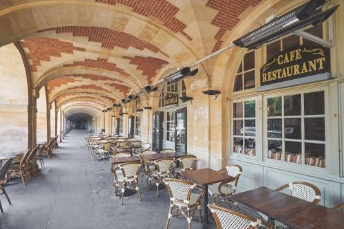 une rangée de tables et de chaises dans un restaurant dans l'établissement Sublime flat - Heart of Paris - Le Marais, à Paris