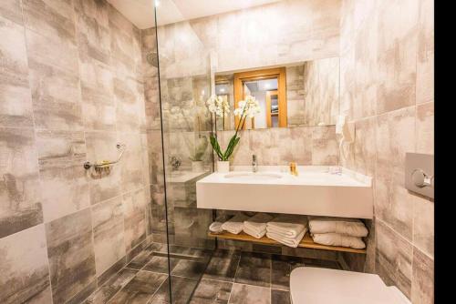een badkamer met een wastafel en een glazen douche bij INGATE Hotel in Famagusta