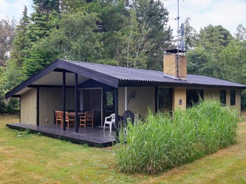 Bøtø Byにある8 person holiday home in Idestrupの小さな家で、デッキ(テーブル、椅子付)が備わります。