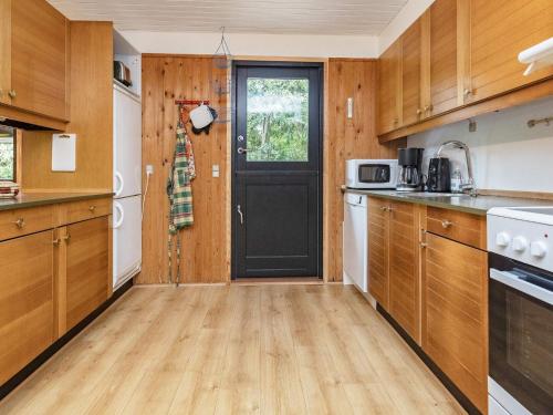 Bøtø Byにある8 person holiday home in Idestrupの木製のキャビネットと黒いドア付きのキッチン