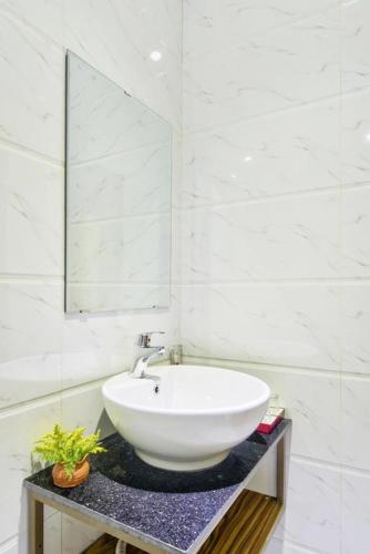 a white bathroom with a sink and a mirror at Annie Danang Hotel & Apartment in Danang