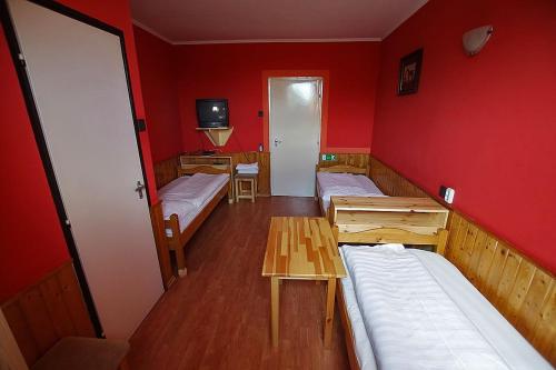 Habitación con 2 camas y pared roja. en Kispipa Panzió, en Szombathely