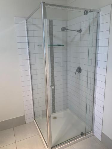 a shower with a glass door in a bathroom at Tea House Motor Inn in Bendigo