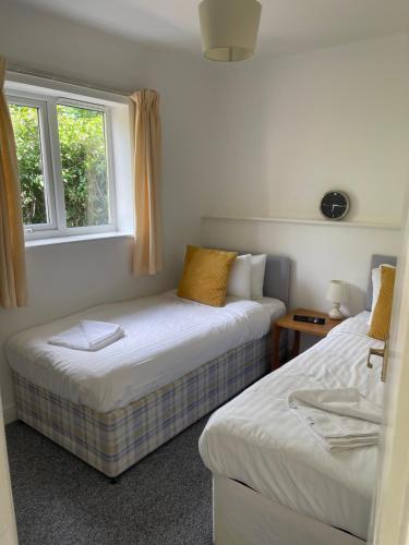 two beds in a room with two windows at Family Bungalow sleeps 4 in Wellington