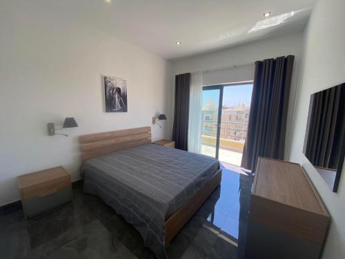 1 dormitorio con cama y ventana grande en Frank's 350 Sqm Churchill Penthouse, en San Ġwann