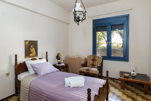 um quarto com uma cama, uma cadeira e uma janela em Thalassa House em Néa Artáki