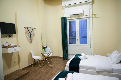 a hotel room with two beds and a window at Hathor House in Cairo