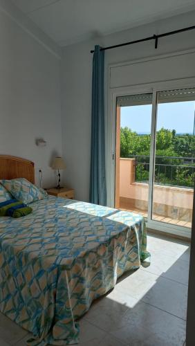 - une chambre avec un lit et une grande fenêtre dans l'établissement Casa unifamiliar con patio y piscina en L'Estartit- Costa Brava, à L'Estartit