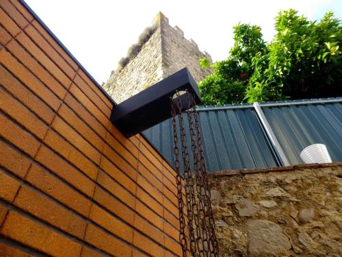 una pared de ladrillo con una valla de cadena en Casa da Torre by Portus Alacer, en Portalegre