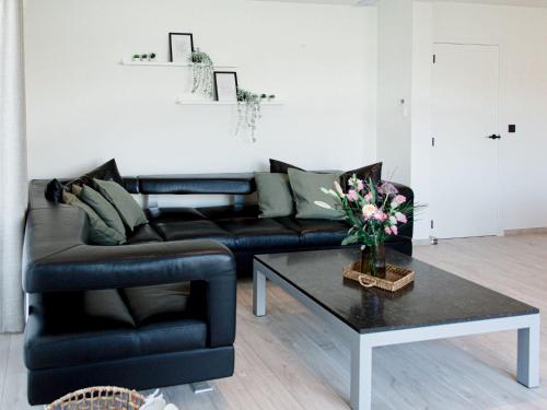 a living room with a black leather couch and a coffee table at Vakantiedorp Marinapark in Westende