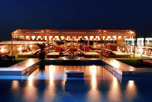 a building with a large swimming pool at night at Movenpick MS Sunray Nile Cruise 4 / 7 Nights Each Thursday From Luxor - 3 Nights Each Monday From Aswan in Luxor