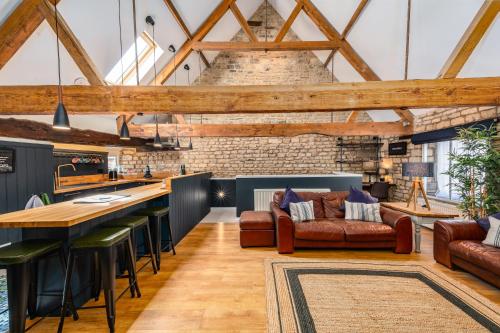 an open kitchen and living room with exposed beams at Stylish central 6 bedroom converted Granary in Stamford