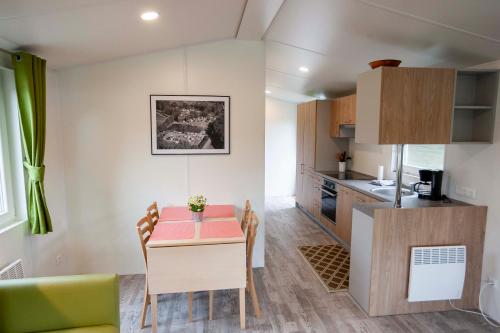 a small kitchen and dining room with a table and chairs at Randbøldal Camping & Cabins in Randbøl