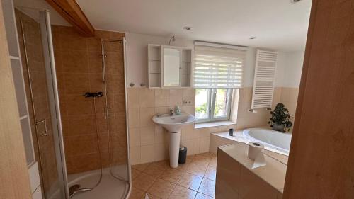 a bathroom with a shower and a sink and a tub at Ferienhaus im Grünen 