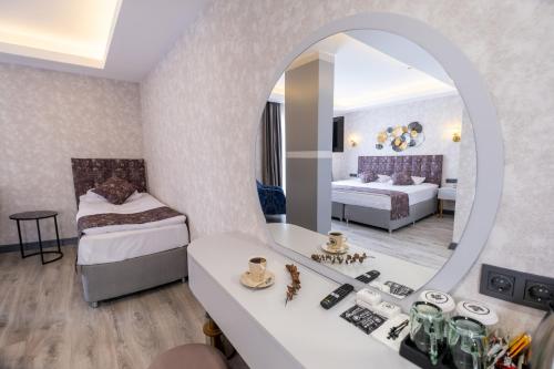 Habitación de hotel con 2 camas y espejo en Avion Suite Hotel en Antalya
