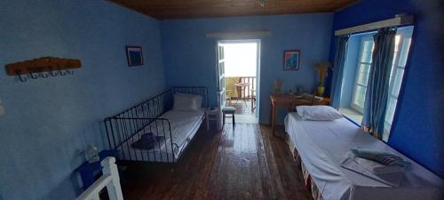 a blue room with two beds and a window at Pilion-Unique House at the Aegean Sea in Keramídhion