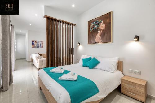 een slaapkamer met een groot bed met handdoeken erop bij Stylish & Modern 1 BR Duplex APT in St Julians by 360 Estates in St Julian's
