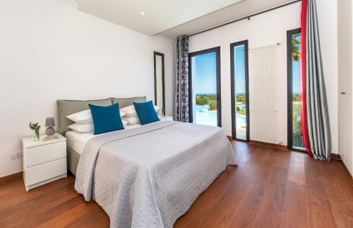ein Schlafzimmer mit einem großen Bett mit blauen Kissen in der Unterkunft Villa Flavia in Polignano a Mare
