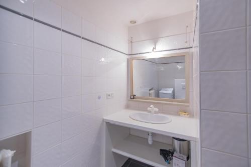 uma casa de banho branca com um lavatório e um espelho em Maison L'Ibie - Avec vue sur la montagne em Vallon-Pont-dʼArc
