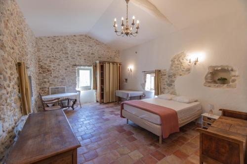 um quarto com uma cama e uma mesa num quarto em Maison L'Ibie - Avec vue sur la montagne em Vallon-Pont-dʼArc