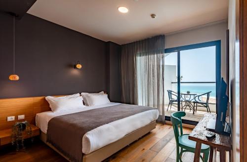 a bedroom with a bed and a view of the ocean at Sea Life Nahariya BY Jacob Hotels in Nahariyya