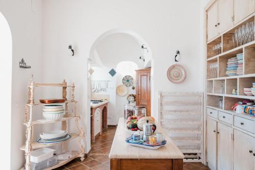 una cucina con pareti bianche e tavolo in legno di Villa Petite Syrene by Elite Villas a Positano