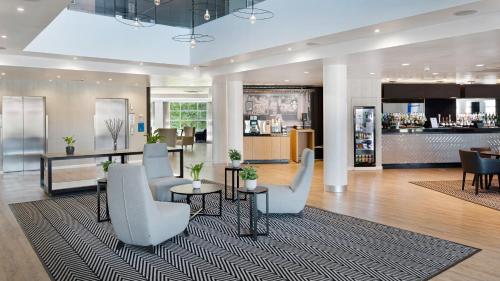 a lobby with chairs and tables and a bar at Holiday Inn Express Leigh - Sports Village, an IHG Hotel in Leigh