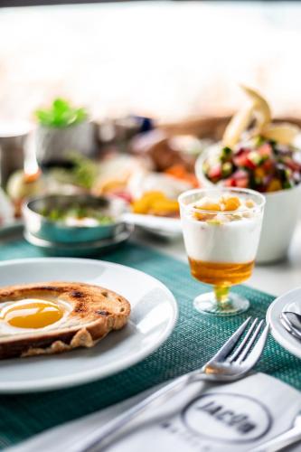 a table with a plate of breakfast food and a drink at Jacob Sea Life Nahariya in Nahariyya