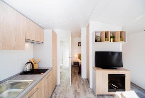 a kitchen with a sink and a tv on a counter at Randbøldal Camping & Cabins in Randbøl
