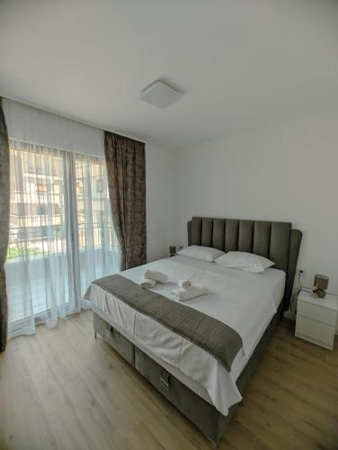 a bedroom with a large bed and a large window at Apartment Laterna in Budva