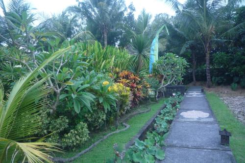un camino a través de un jardín con plantas y palmeras en Gerebig Bungalow, en Ubud