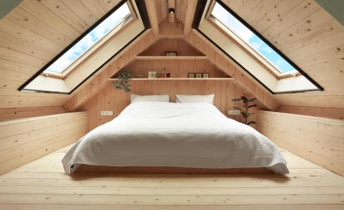 a bedroom with a bed in a room with skylights at Vakantiehuisje Buuf in de Brabantse natuur in Schijndel