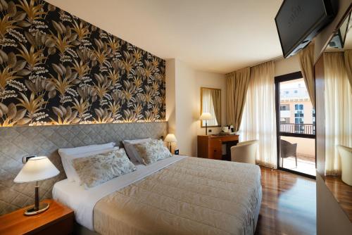 a hotel room with a bed and a wall mural at Savoy Beach Hotel & Thermal Spa in Bibione