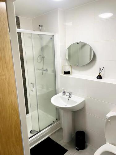a white bathroom with a shower and a sink at #222 1 Bed Serviced Apartment in Derby