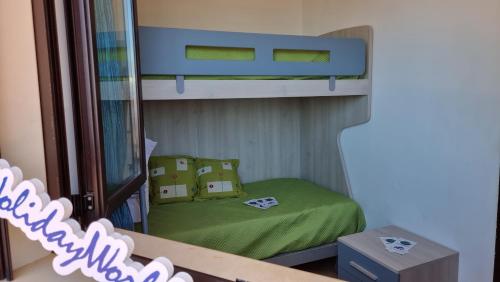 a bunk bed with green sheets and pillows in a room at Las Terrazas sobre el Mar by Holiday World in Marina di Palma