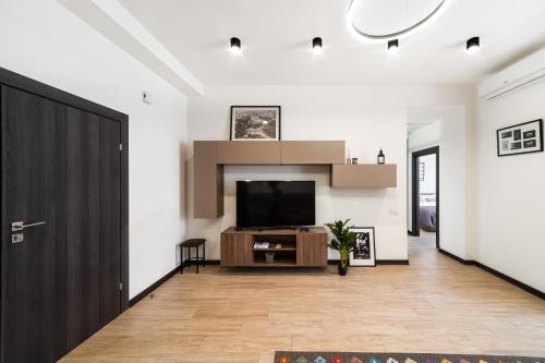 a living room with a flat screen tv and a door at hotelise I Matata Apartment in Yerevan