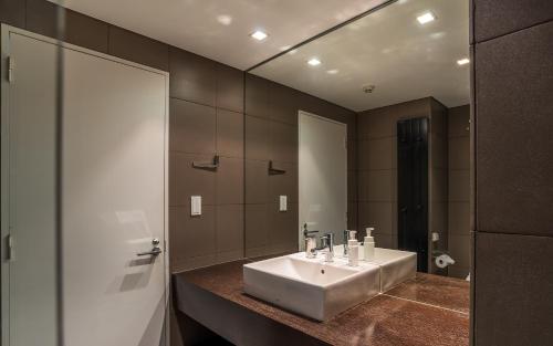 a bathroom with a sink and a large mirror at The Setsumon in Kutchan