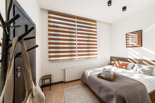 a bedroom with a bed and a window at hotelise I Matata Apartment in Yerevan