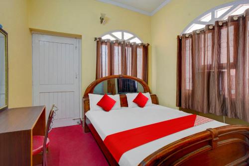 a bedroom with a large bed with red pillows at Flagship Hotel Heaven Inn in Patna