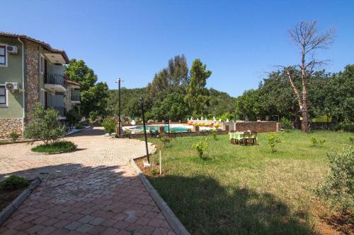 a backyard of a house with a garden and a pool at Yeşilkaya Hotel in Kayakoy