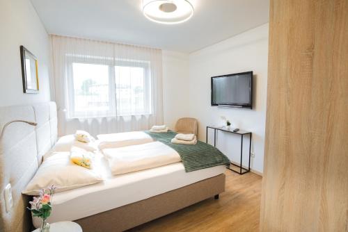 a bedroom with a bed and a tv on the wall at Haus Bachinger in Mondsee