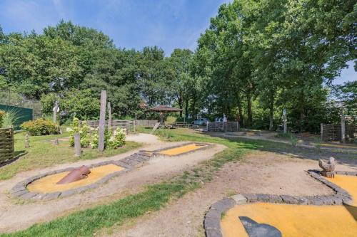a playground in a park with trees at 8 pers vakantiehuis met natuur- sauna en bubbelbad in Diessen